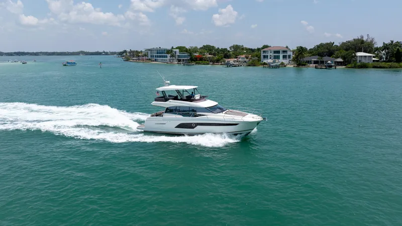 Motivated Seller Yacht Photos Pics Prestige 520 yacht cruising on a sunny day, 2019 model, near coastal homes.