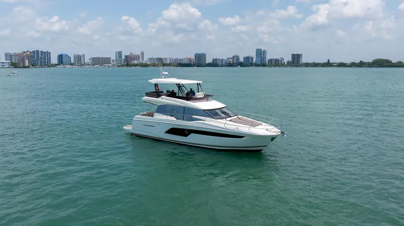 Motivated Seller Yacht Photos Pics 2019 Prestige 520 yacht cruising on a sunny day with city skyline in background.