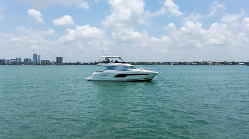 Motivated Seller Yacht Photos Pics 2019 Prestige 520 yacht cruising on a calm sea under a partly cloudy sky.