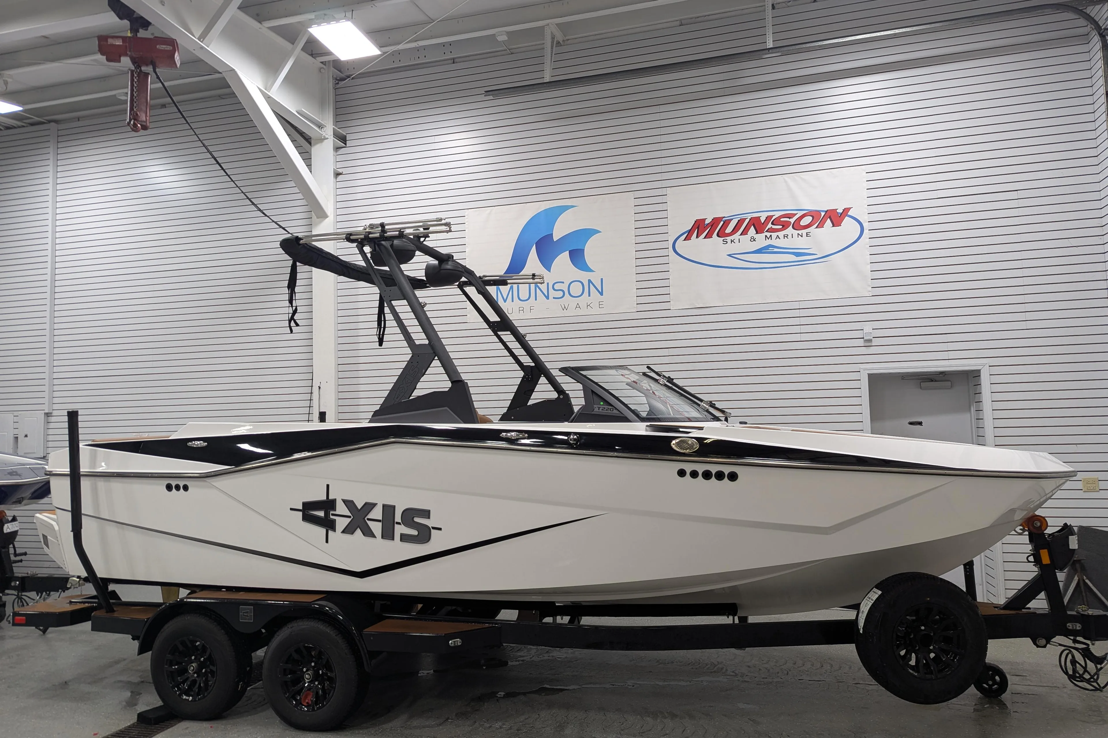 2025 Axis T220 boat on trailer in showroom with Munson signage.
