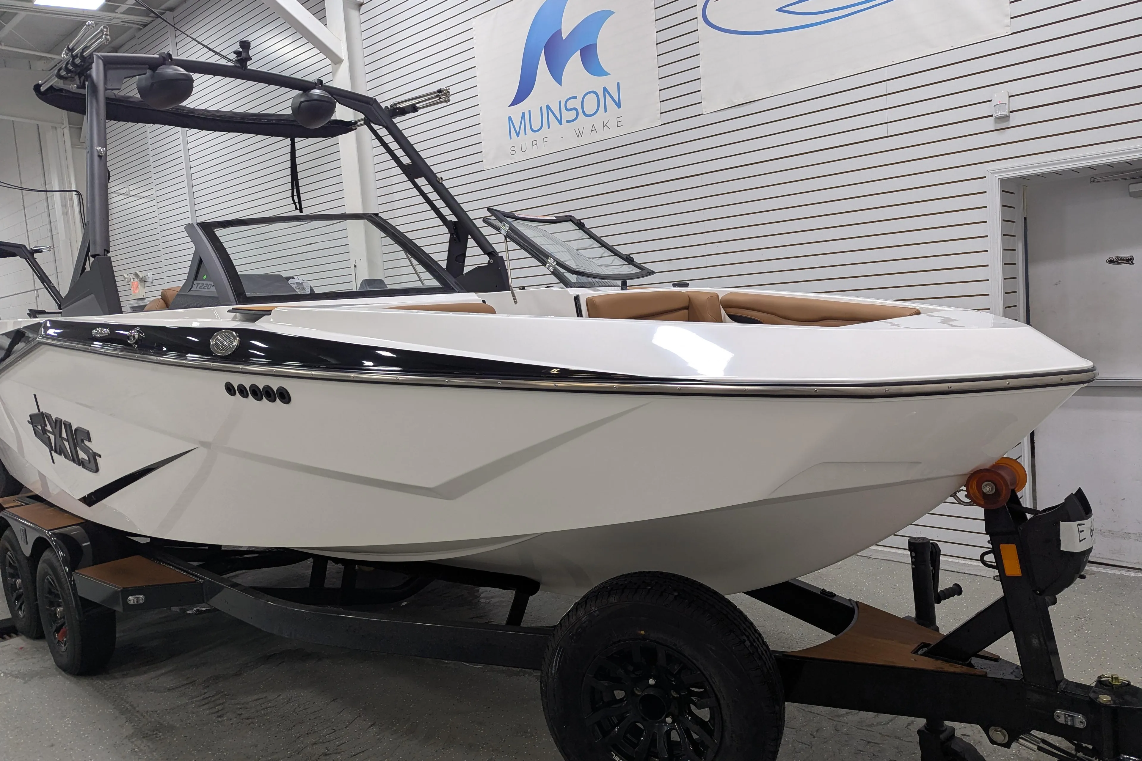 2025 Axis T220 boat on trailer in showroom, featuring sleek design and modern features.