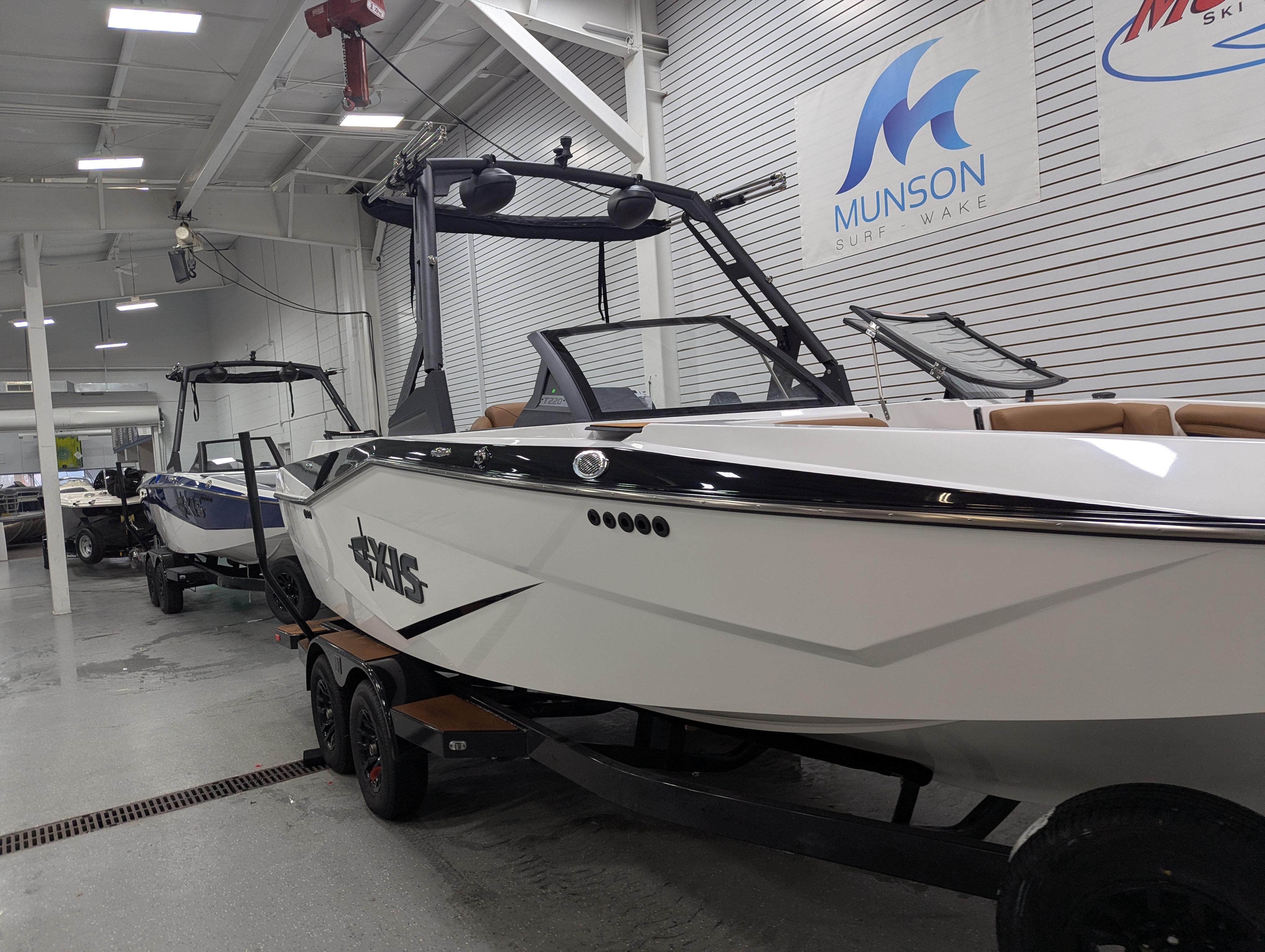 2025 Axis T220 boat in showroom, sleek design, Munson Ski & Marine signage.