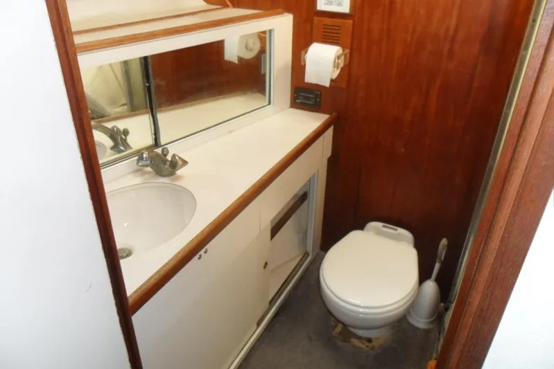  Yacht Photos Pics 1979 Bertram 46.6 Sport Fisher bathroom with sink, mirror, and toilet.