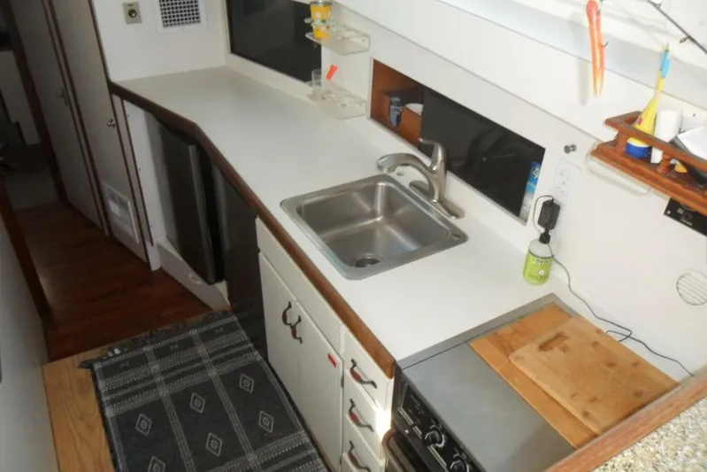  Yacht Photos Pics 1979 Bertram 46.6 Sport Fisher kitchen with sink, stove, and countertop.