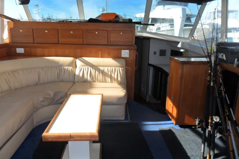  Yacht Photos Pics Interior of 1979 Bertram 46.6 Sport Fisher with seating, table, and fishing rods.