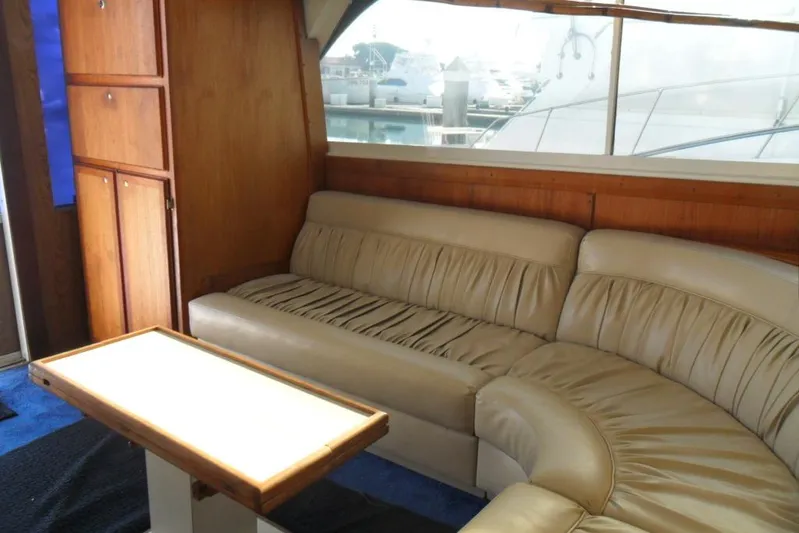  Yacht Photos Pics 1979 Bertram 46.6 Sport Fisher interior with beige leather seating and wooden cabinetry.