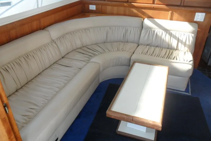  Yacht Photos Pics 1979 Bertram 46.6 Sport Fisher interior with beige leather seating and wooden table.