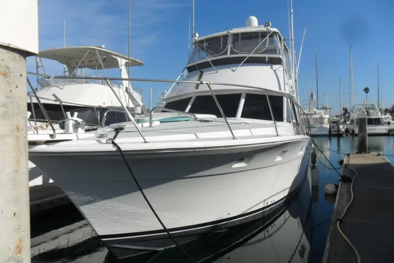  Yacht Photos Pics 1979 Bertram 46.6 Sport Fisher yacht docked in a marina under clear blue skies.