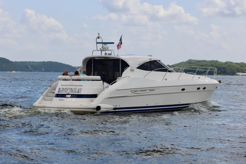  Yacht Photos Pics 1999 Neptunus 54 Hardtop Express yacht cruising on a scenic lake.