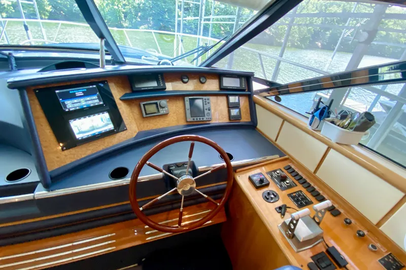  Yacht Photos Pics Cockpit of 1999 Neptunus 54 Hardtop Express yacht with steering wheel and control panel.