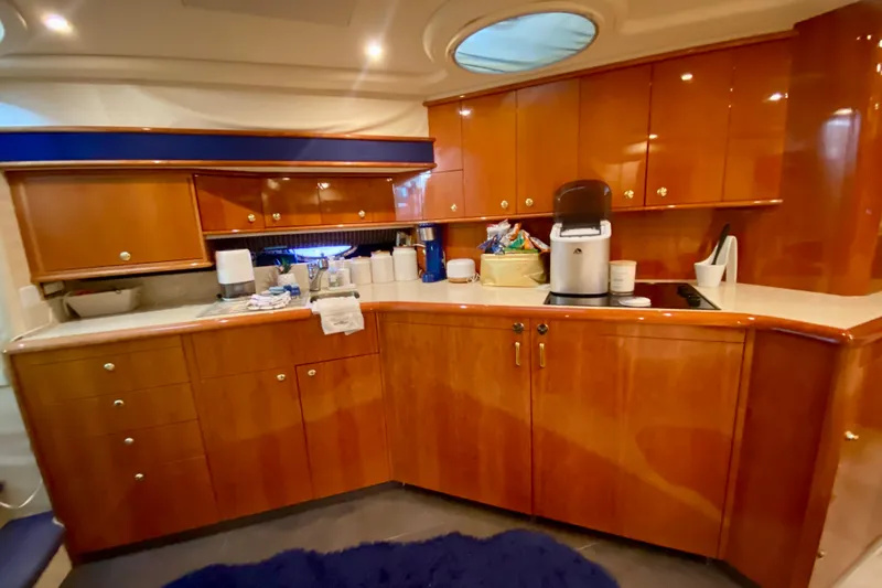  Yacht Photos Pics Luxurious kitchen interior of 1999 Neptunus 54 Hardtop Express yacht with wooden cabinetry.