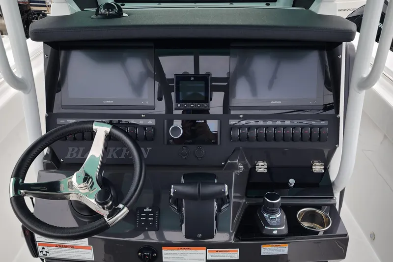  Yacht Photos Pics 2023 Blackfin 272 CC boat dashboard with steering wheel and electronic controls.