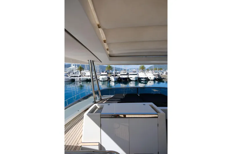  Yacht Photos Pics View from 2020 Lagoon 630 MY yacht, overlooking marina with docked boats and palm trees.