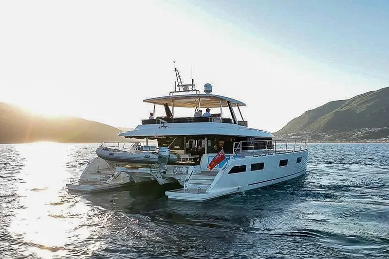  Yacht Photos Pics Luxurious 2020 Lagoon 630 MY yacht cruising at sunset near scenic coastline.