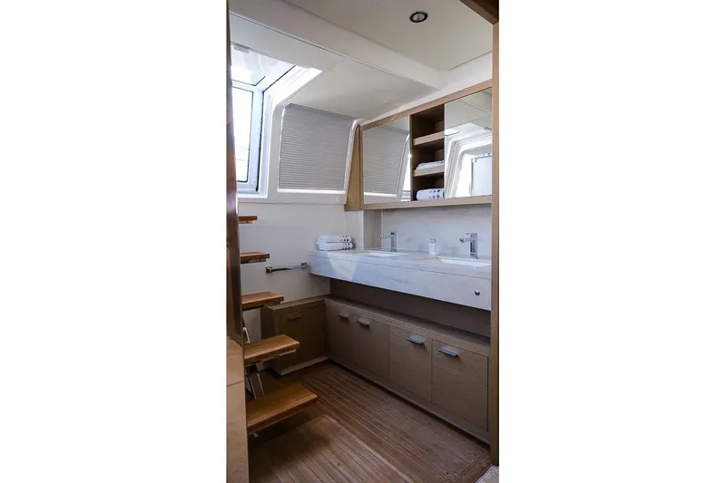  Yacht Photos Pics Luxurious bathroom interior of 2020 Lagoon 630 MY yacht with modern fixtures and wooden accents.