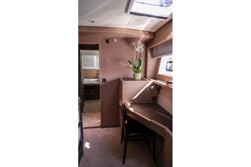  Yacht Photos Pics Luxurious interior of 2020 Lagoon 630 MY yacht with desk and potted plant.