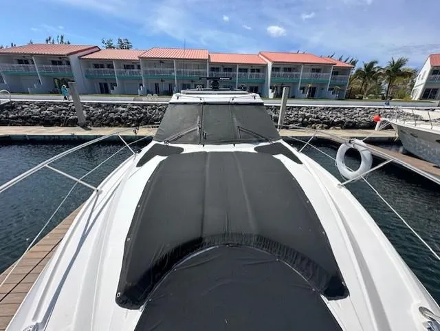 Namaste III Yacht Photos Pics 2010 Four Winns V435 yacht docked at marina with waterfront buildings in background.