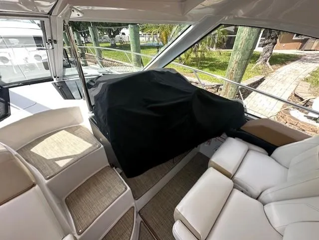 Namaste III Yacht Photos Pics Interior of 2010 Four Winns V435 yacht with white seating and covered console.
