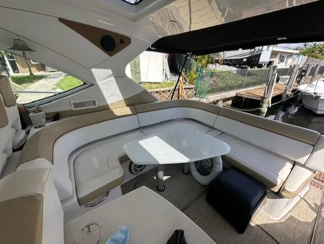Namaste III Yacht Photos Pics 2010 Four Winns V435 yacht interior with beige seating and table, docked at marina.