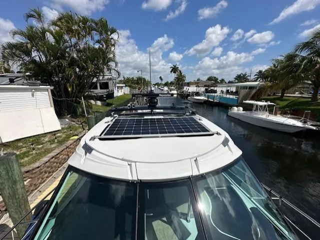 Namaste III Yacht Photos Pics 2010 Four Winns V435 yacht with solar panels, docked in a scenic canal.