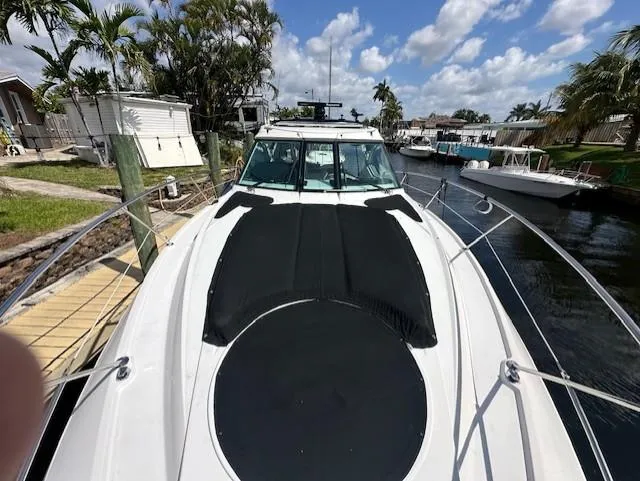 Namaste III Yacht Photos Pics 2010 Four Winns V435 yacht docked by a canal under a partly cloudy sky.