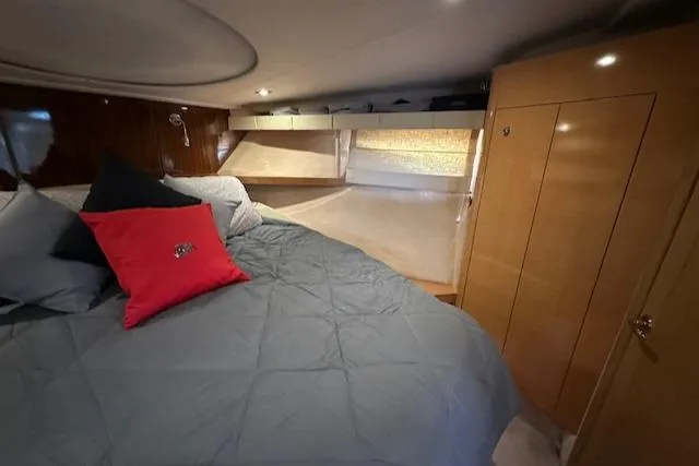 Namaste III Yacht Photos Pics Luxurious cabin interior of 2010 Four Winns V435 yacht with cozy bedding and wooden cabinetry.