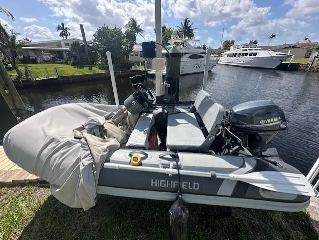 Namaste III Yacht Photos Pics Inflatable boat with Yamaha motor docked near canal, sunny day, palm trees in background.