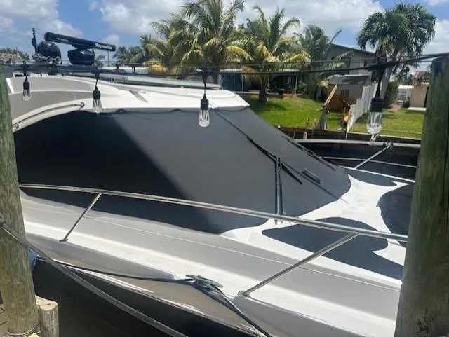 Namaste III Yacht Photos Pics 2010 Four Winns V435 boat docked with sunshade, surrounded by palm trees.
