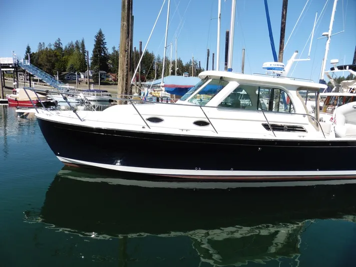  Yacht Photos Pics 2016 Back Cove 30 boat docked in a marina, reflecting on calm water.