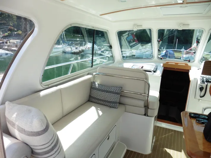  Yacht Photos Pics 2016 Back Cove 30 yacht interior with plush seating and large windows in a marina setting.