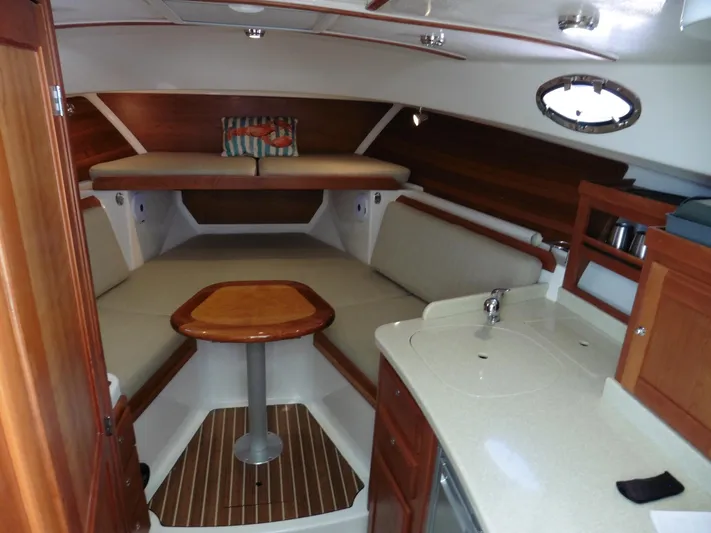  Yacht Photos Pics Interior of 2016 Back Cove 30 boat with seating, table, and kitchenette.