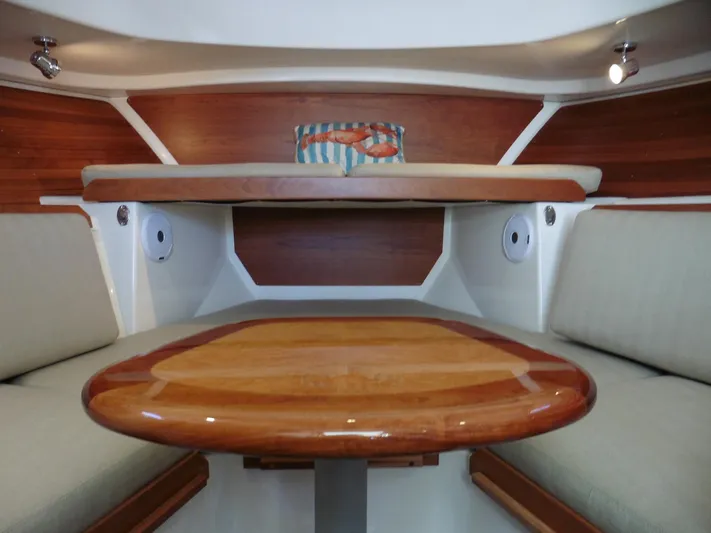  Yacht Photos Pics Interior of 2016 Back Cove 30 boat with wooden table and cushioned seating.