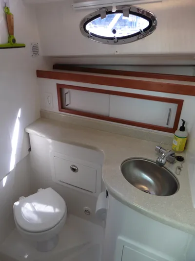  Yacht Photos Pics 2016 Back Cove 30 yacht bathroom with sink, toilet, and porthole window.