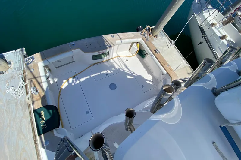 El Patron Yacht Photos Pics 2005 Cabo 40 Hardtop Express boat deck with fishing rod holders and dock view.