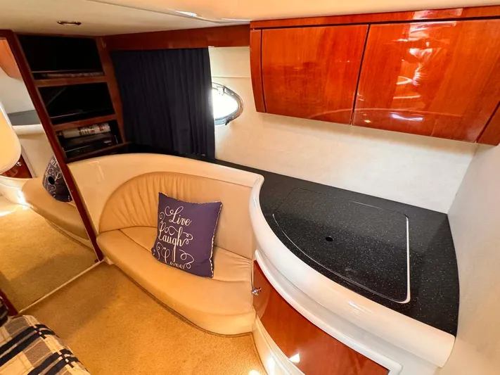 Pave The Wave VII Yacht Photos Pics 2005 Fairline Targa 40 interior with curved seating, wooden cabinets, and decorative pillow.