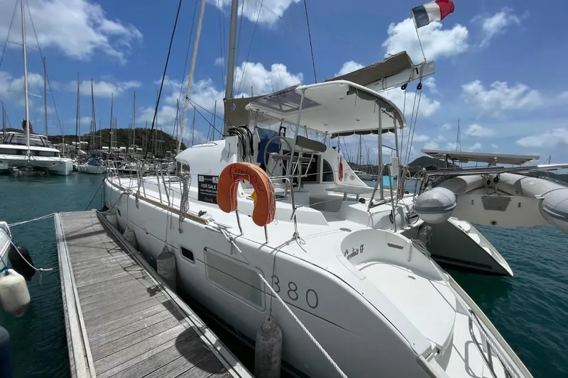 Carnabie Yacht Photos Pics 2014 Lagoon 380 S2 catamaran docked, with a "For Sale" sign and lifebuoy.