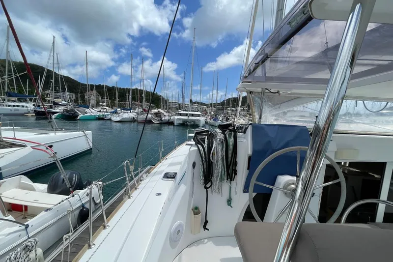 Carnabie Yacht Photos Pics 2014 Lagoon 380 S2 catamaran docked in a marina, surrounded by sailboats.