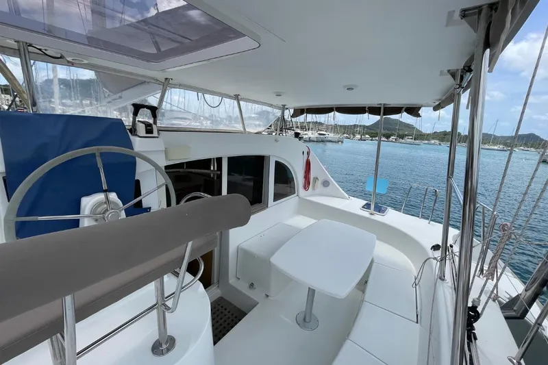 Carnabie Yacht Photos Pics 2014 Lagoon 380 S2 catamaran cockpit with steering wheel and seating, docked in marina.