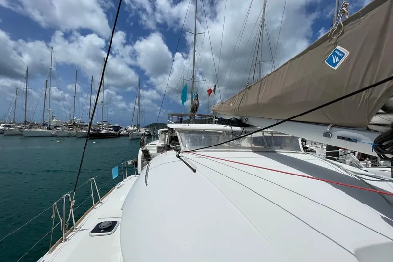 Carnabie Yacht Photos Pics 2014 Lagoon 380 S2 catamaran docked in a marina under a partly cloudy sky.