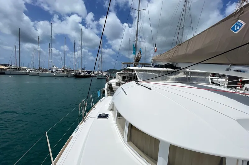 Carnabie Yacht Photos Pics 2014 Lagoon 380 S2 catamaran docked in a marina under a partly cloudy sky.