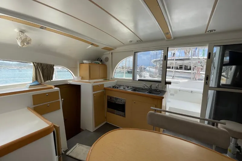 Carnabie Yacht Photos Pics Interior of 2014 Lagoon 380 S2 catamaran with kitchen and dining area, docked at marina.