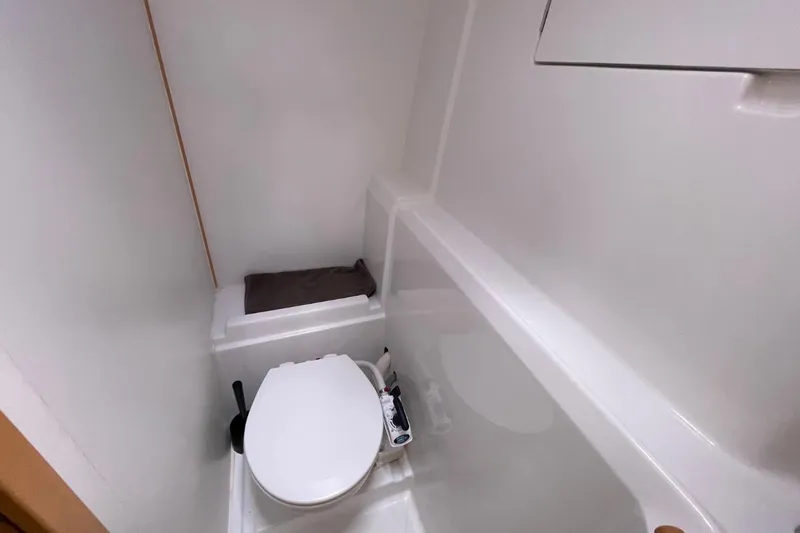 Carnabie Yacht Photos Pics Compact bathroom in a 2014 Lagoon 380 S2 yacht, featuring a white toilet and minimalistic design.