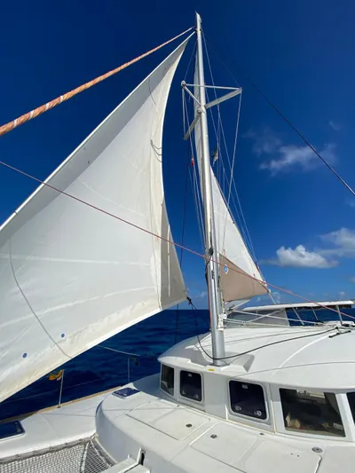 Carnabie Yacht Photos Pics Sailing catamaran Lagoon 380 S2, 2014 model, with white sails against a clear blue sky.