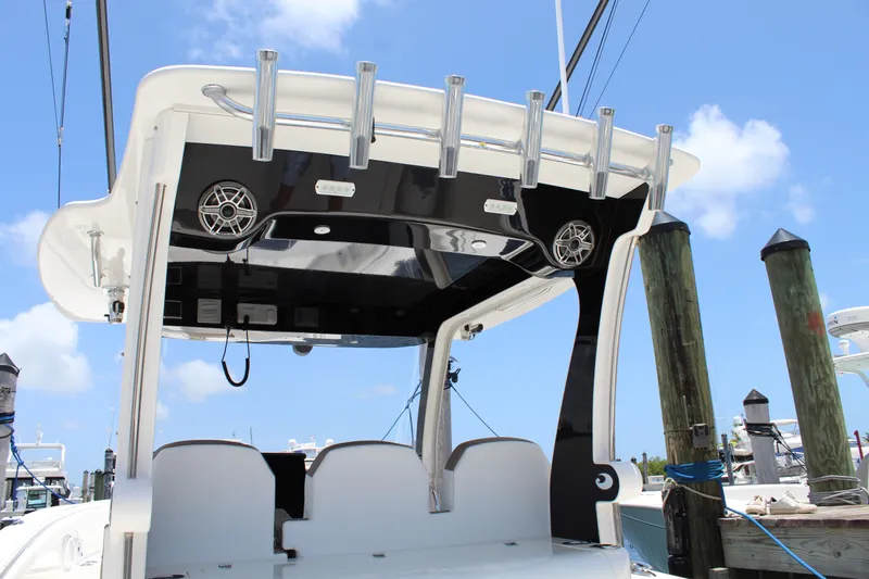  Yacht Photos Pics 2016 Edgewater 370CC boat with rod holders and speakers, docked under a clear blue sky.