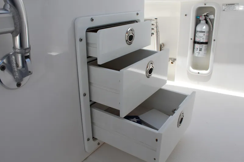  Yacht Photos Pics Open storage drawers on a 2016 Edgewater 370CC boat, with a visible fire extinguisher.