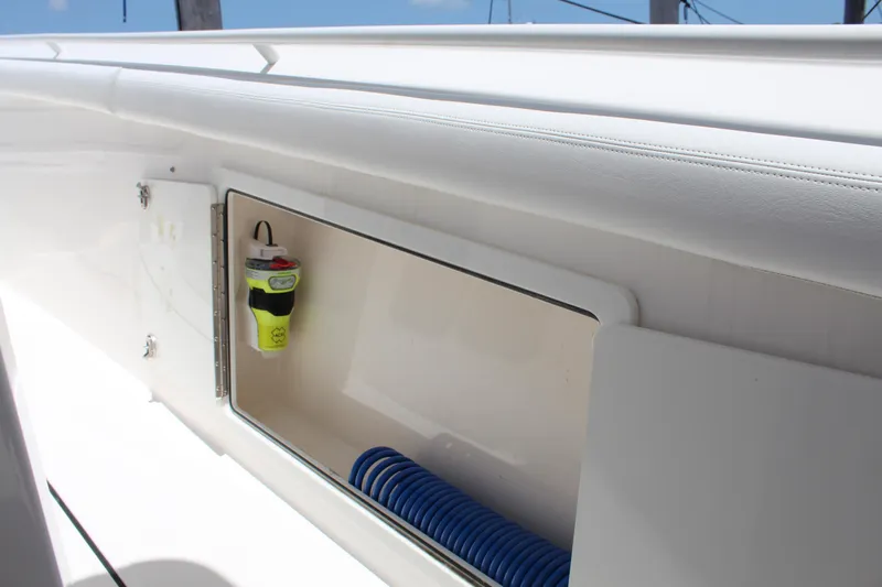 Yacht Photos Pics 2016 Edgewater 370CC boat storage compartment with safety equipment and coiled hose.