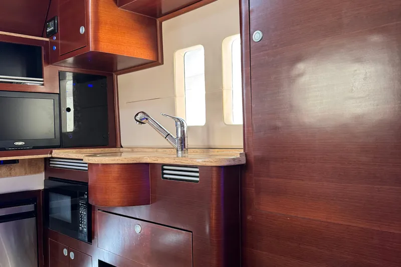  Yacht Photos Pics Interior of 2016 Edgewater 370CC boat featuring a modern kitchenette with wood finish.