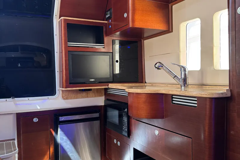  Yacht Photos Pics Interior of 2016 Edgewater 370CC boat with kitchenette, sink, and TV.