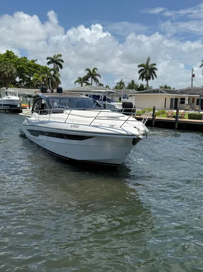  Yacht Photos Pics 2023 Rio Yachts SPORT COUPE on water, surrounded by palm trees and clear skies.