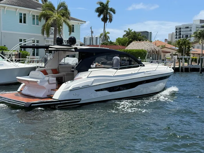  Yacht Photos Pics 2023 Rio Yachts SPORT COUPE cruising on a sunny day near waterfront homes.